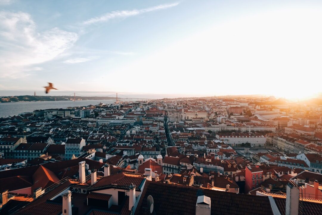 Aerial view of dense residential rooftops in a Lisbon neighbourhood at sunset